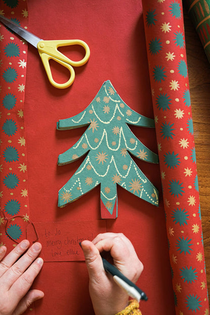 Handmade Christmas tree decoration red paper scissors wrapping paper